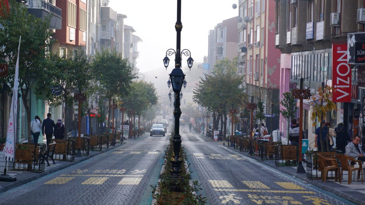 Stradă liniștită dintr-un sat, cu o cafenea mică deschisă dimineața